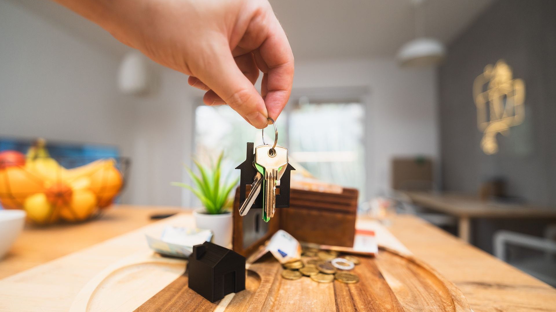 Hand holding the keys to a new home in a modern living room